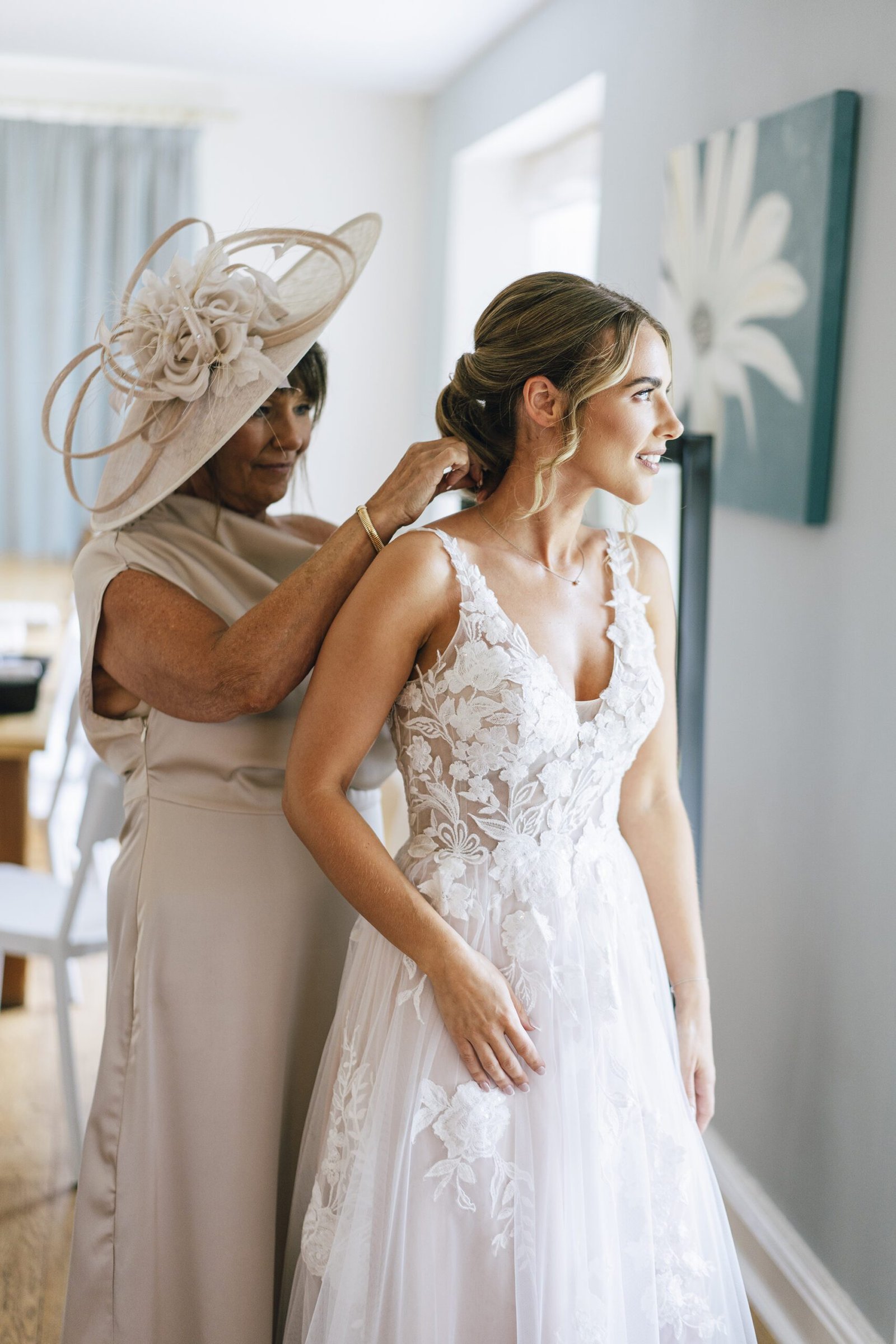 Mother of the bride adjusting brides dress on a