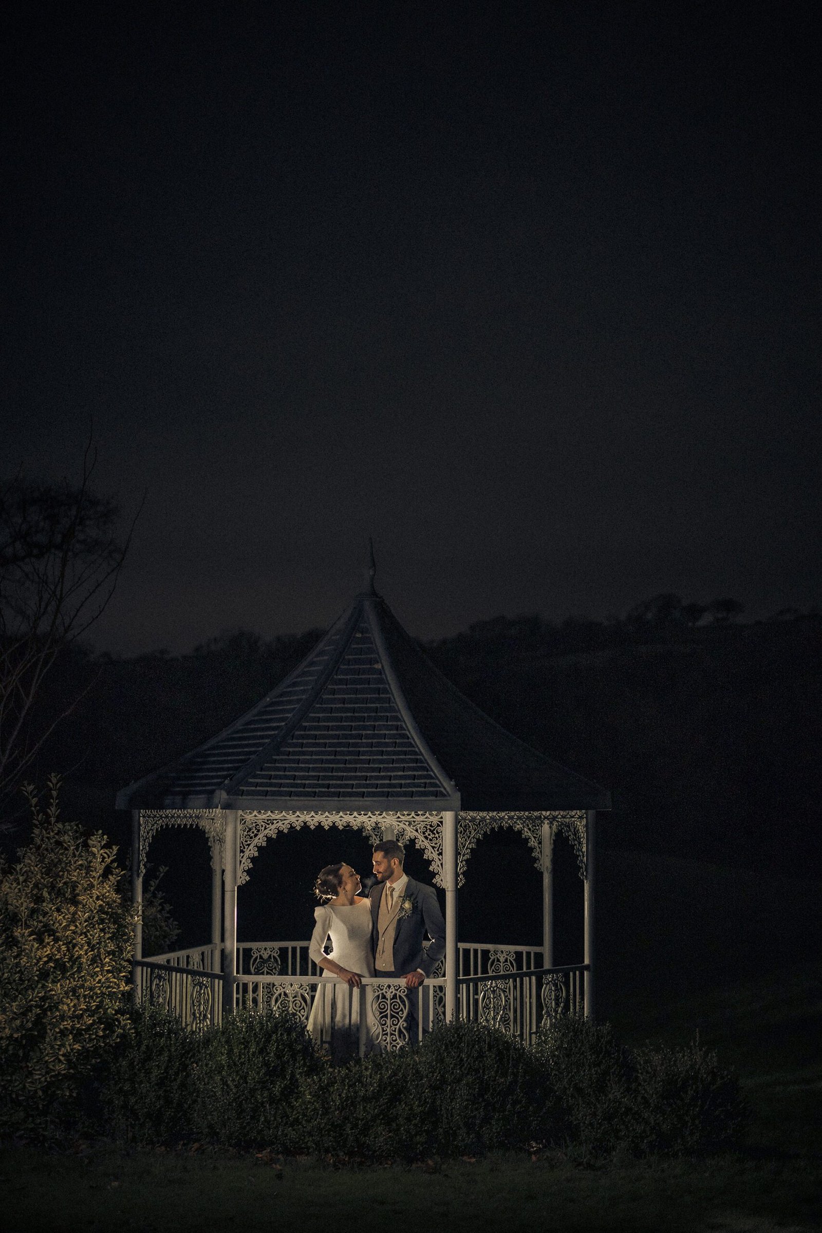 bride & Groom kissing in a gazebo at night at St Elizabeths house