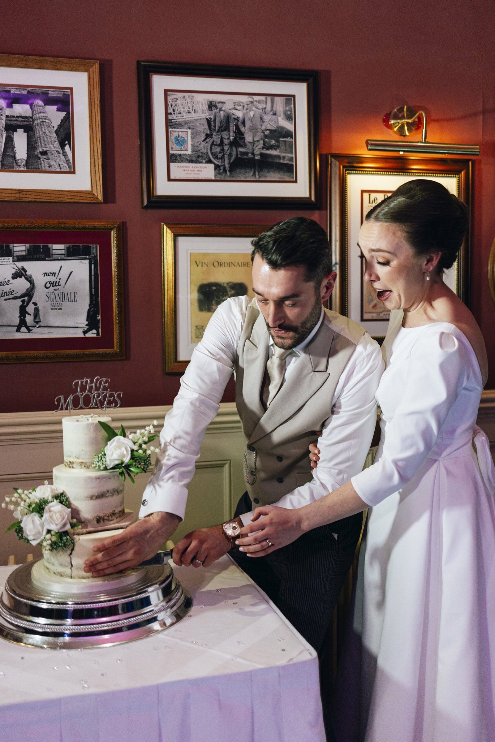 Newlyweds cutting their wedding cake in the stylish reception space of St Elizabeth’s House, Plympton